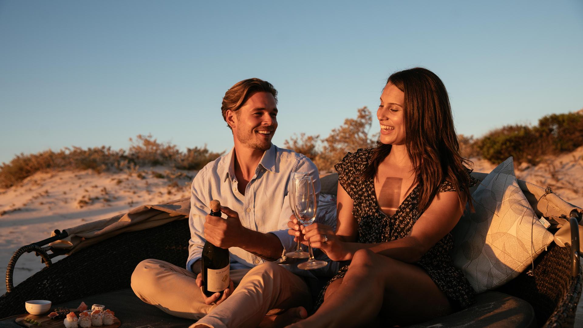 couple drinking champagne during sunset